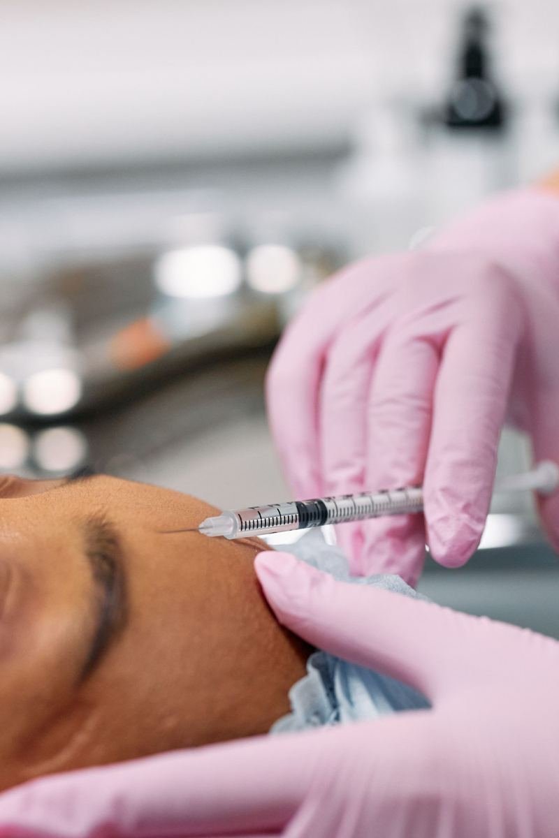 Procedimento estético injetável sendo realizado com luvas